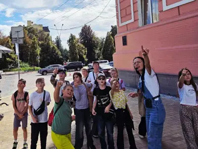 Гід з групою школярів біля будівлі Національної поліції під час одноденного туру Київськими скарбами