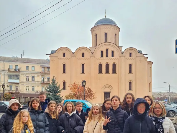 Група школярів на вулиці Подолу із забудовою XVIII століття під час екскурсії Києвом