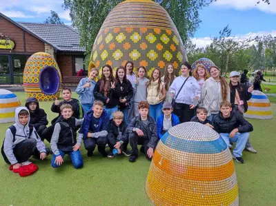 Група школярів біля мозаїчних скульптур яєць на страусиній фермі в Ясногородці під час екскурсії