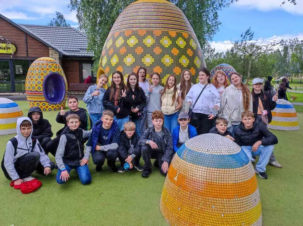 Група школярів біля мозаїчних скульптур яєць на страусиній фермі в Ясногородці під час екскурсії